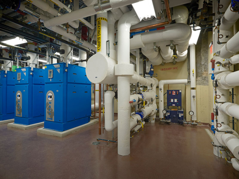 Hospital mechanical room with boilers and piping systems supporting surgical suite expansion