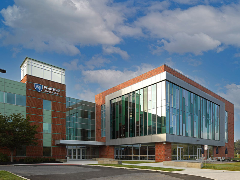 Three-story addition at Penn State Lehigh Valley with brick and glass façade, expanded student center entrance, and large windows providing natural daylight