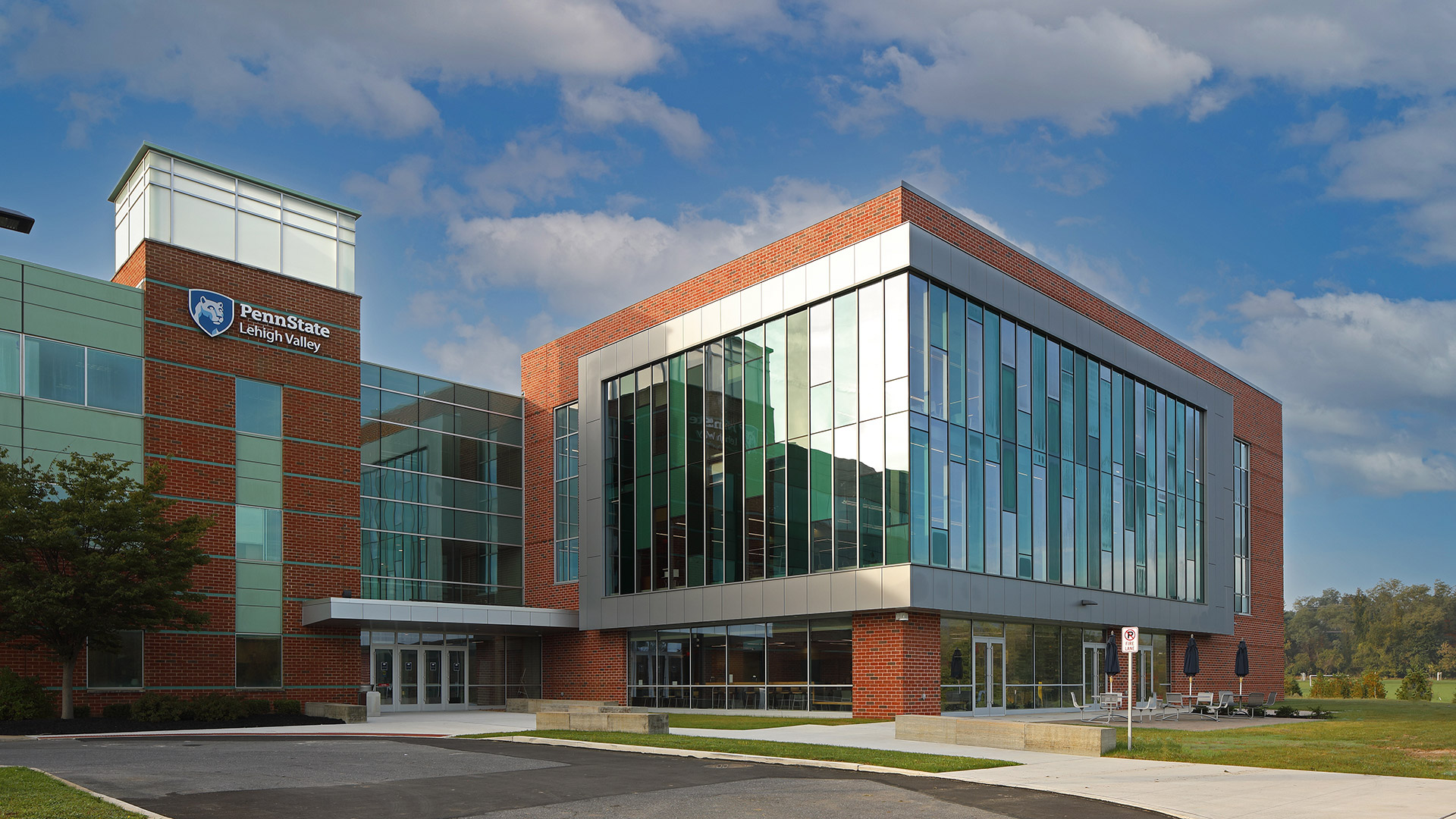 Three-story addition at Penn State Lehigh Valley with brick and glass façade, expanded student center entrance, and large windows providing natural daylight