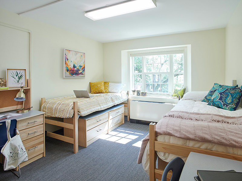 Upgraded student housing room in Drayer Hall at Dickinson College with twin beds, natural daylight, and contemporary finishes