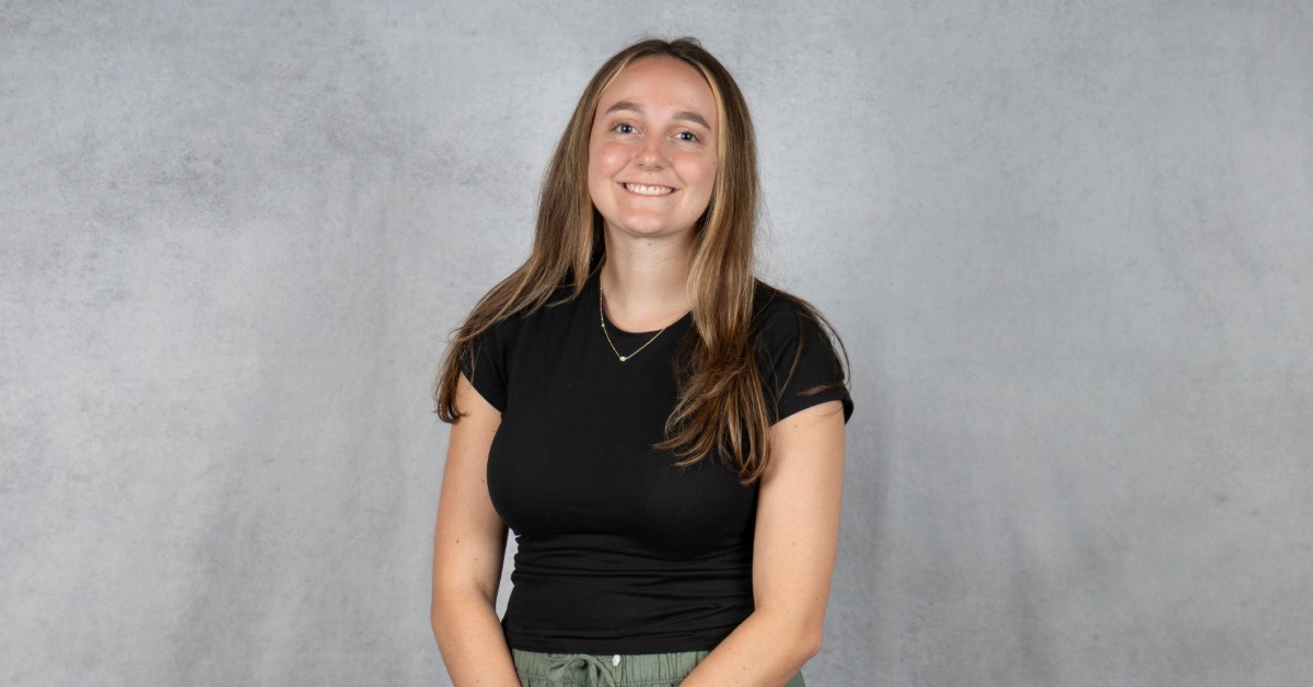 Lauren E. Heisler smiling in a professional headshot against a gray studio background