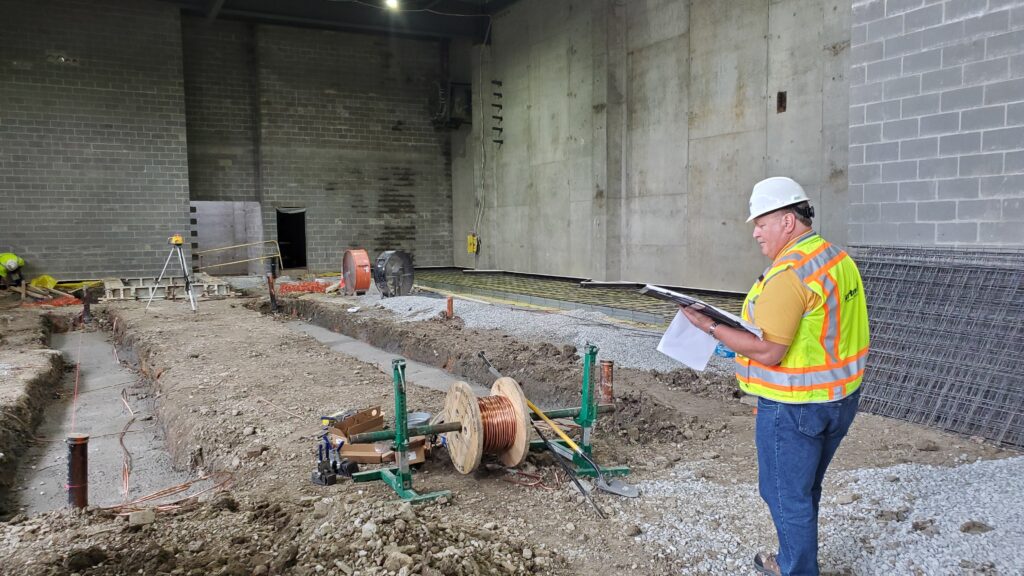 Barton Associates employee reviewing plans at an active jobsite