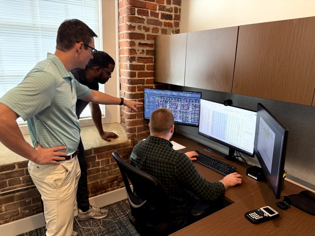 Mentoring at Barton Associates, with team members reviewing engineering plans